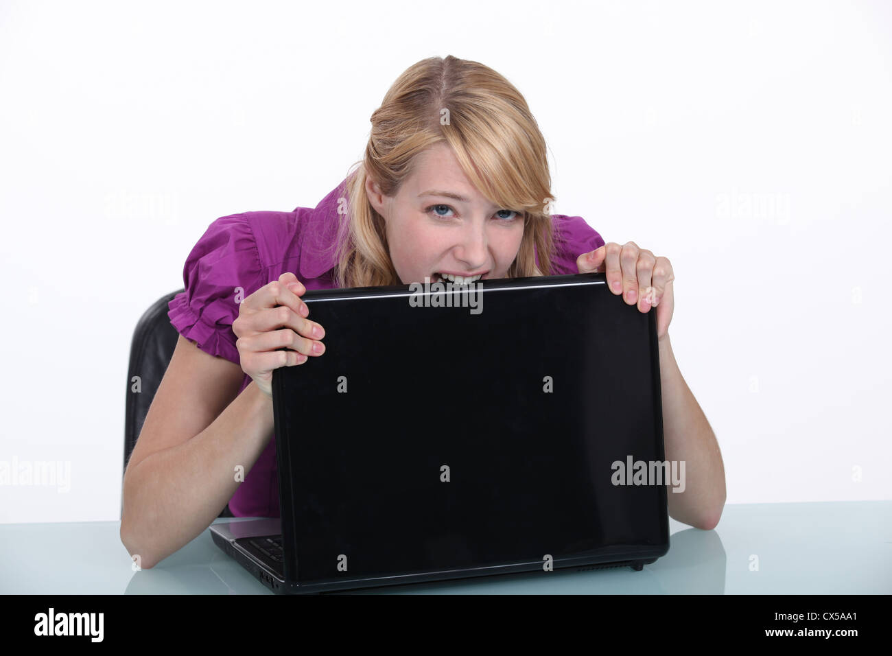 Woman eating her laptop in frustration Stock Photo Alamy