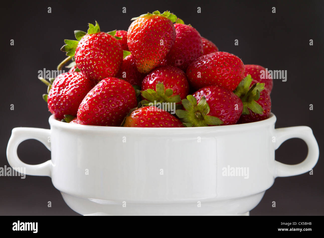 bowl of strawberries over black background Stock Photo - Alamy