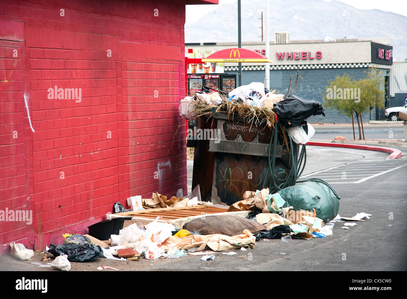 overfilled dumpster in trash neighborhood Stock Photo