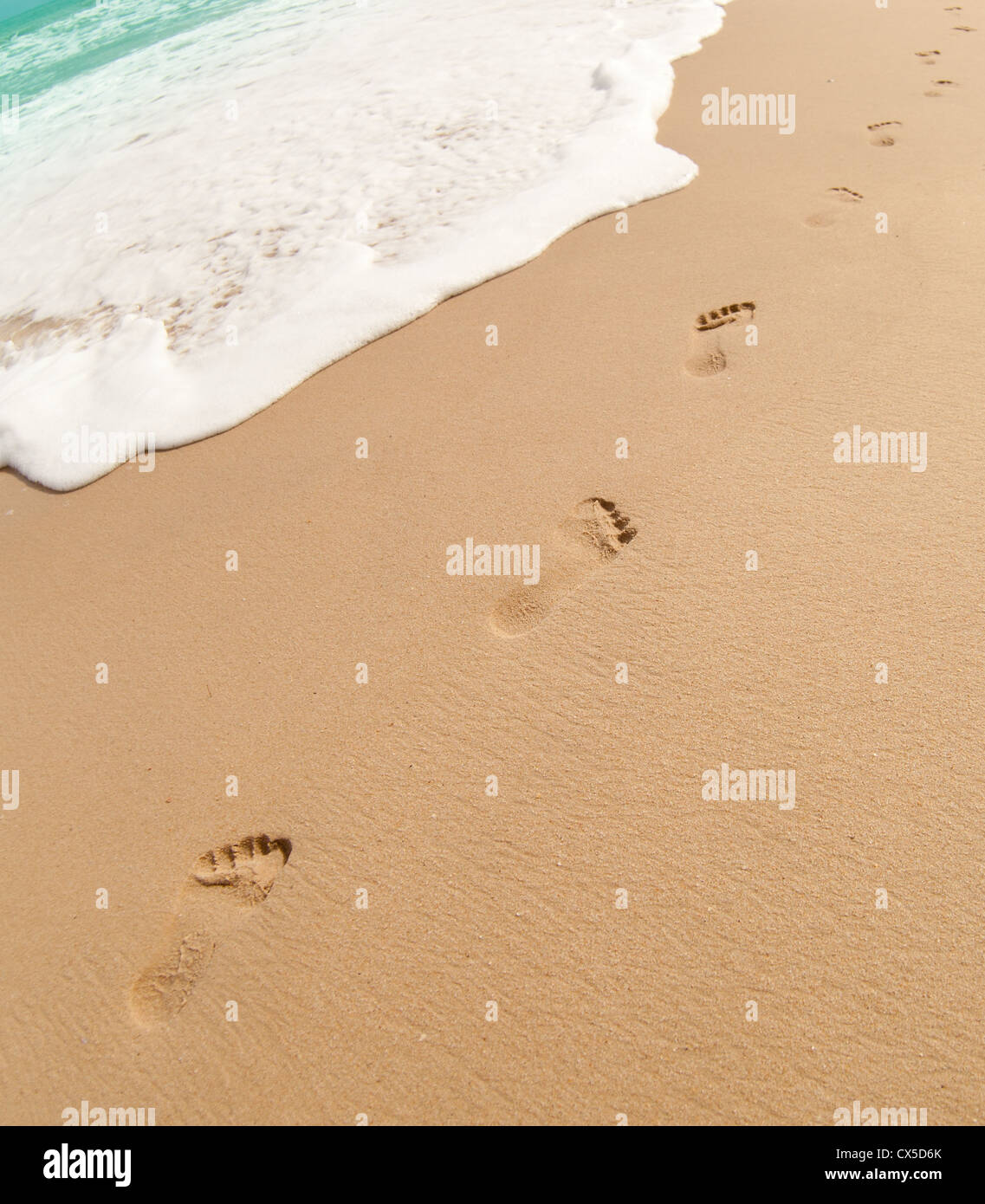 Footprints on sand of ocean beach Stock Photo