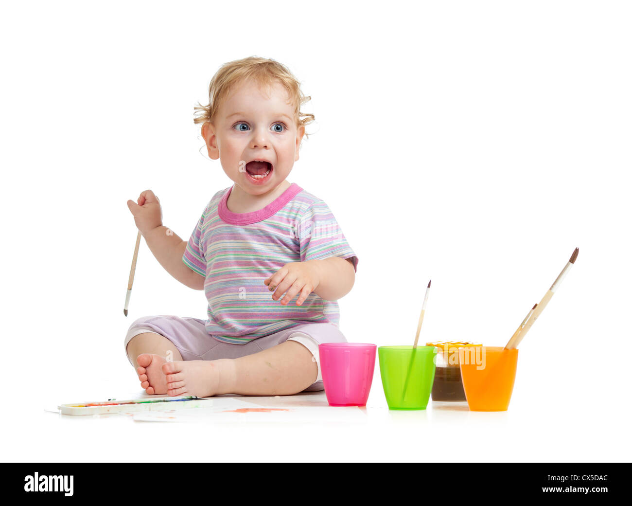 Funny kid with open mouth painting with brush Stock Photo