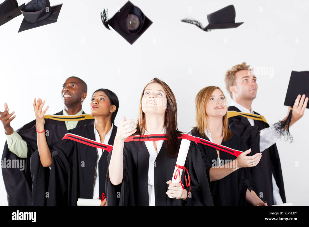 graduates throwing caps at graduation Stock Photo