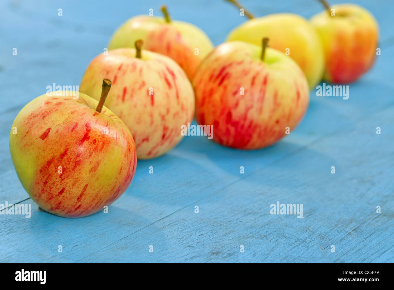Red apples on a blue rustic wooden background Stock Photo - Alamy