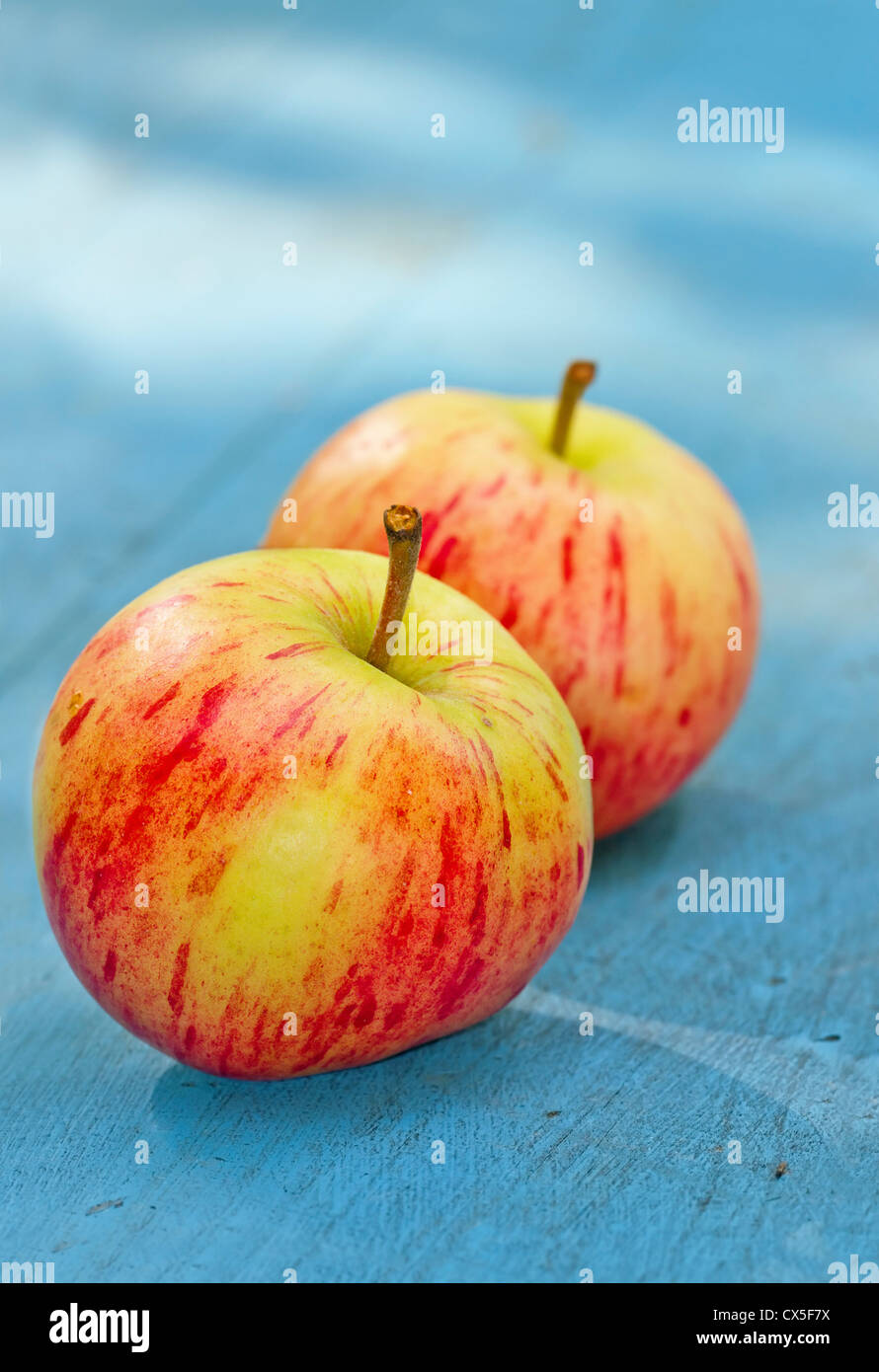 Two red apples on a blue rustic wooden background Stock Photo - Alamy
