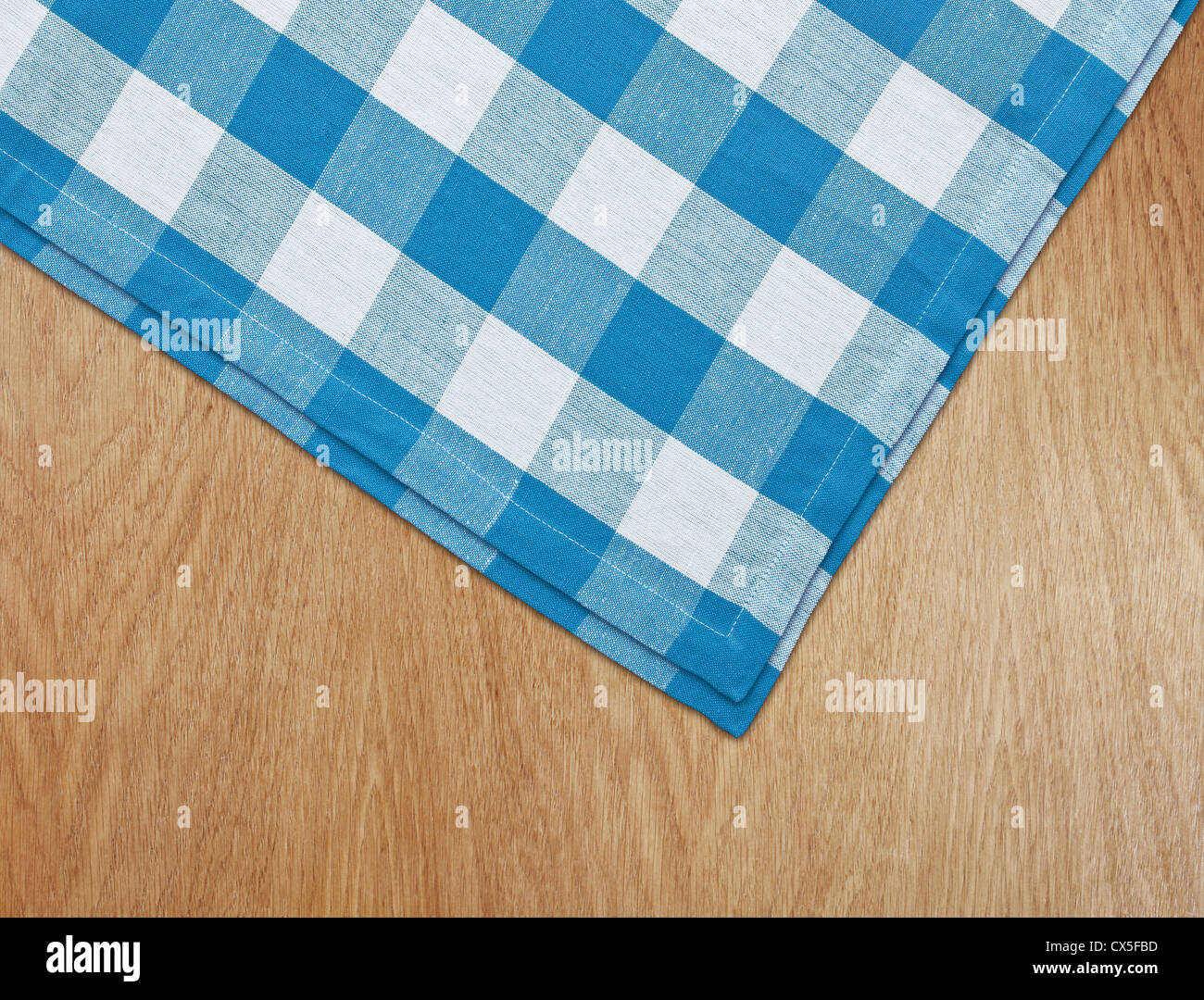 wooden kitchen table with blue gingham tablecloth Stock Photo