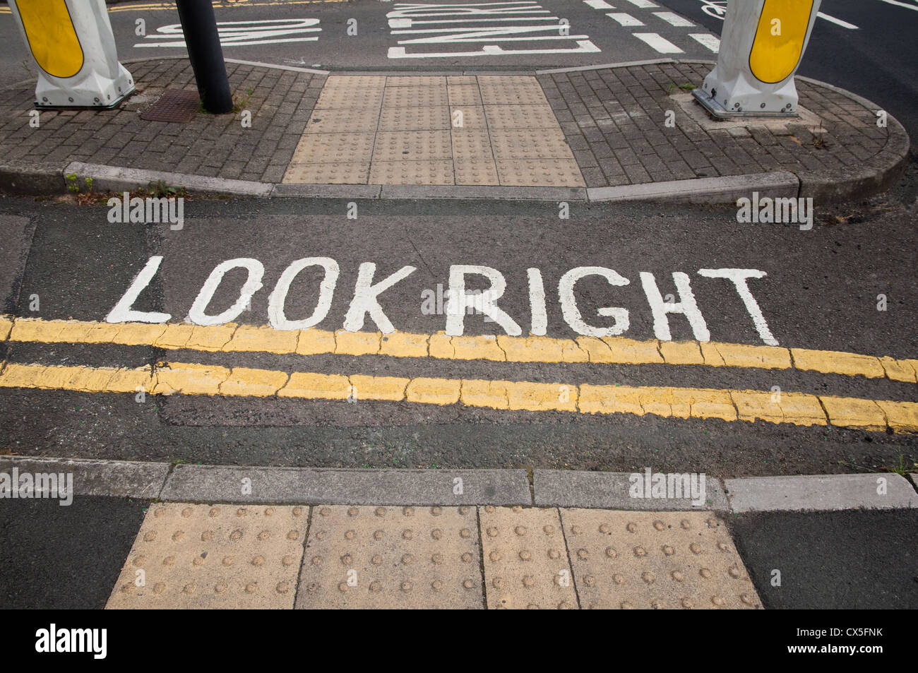 Double Yellow Lines and Look Right Notice - within a cycle lane and pedestrian crossing.  UK Stock Photo