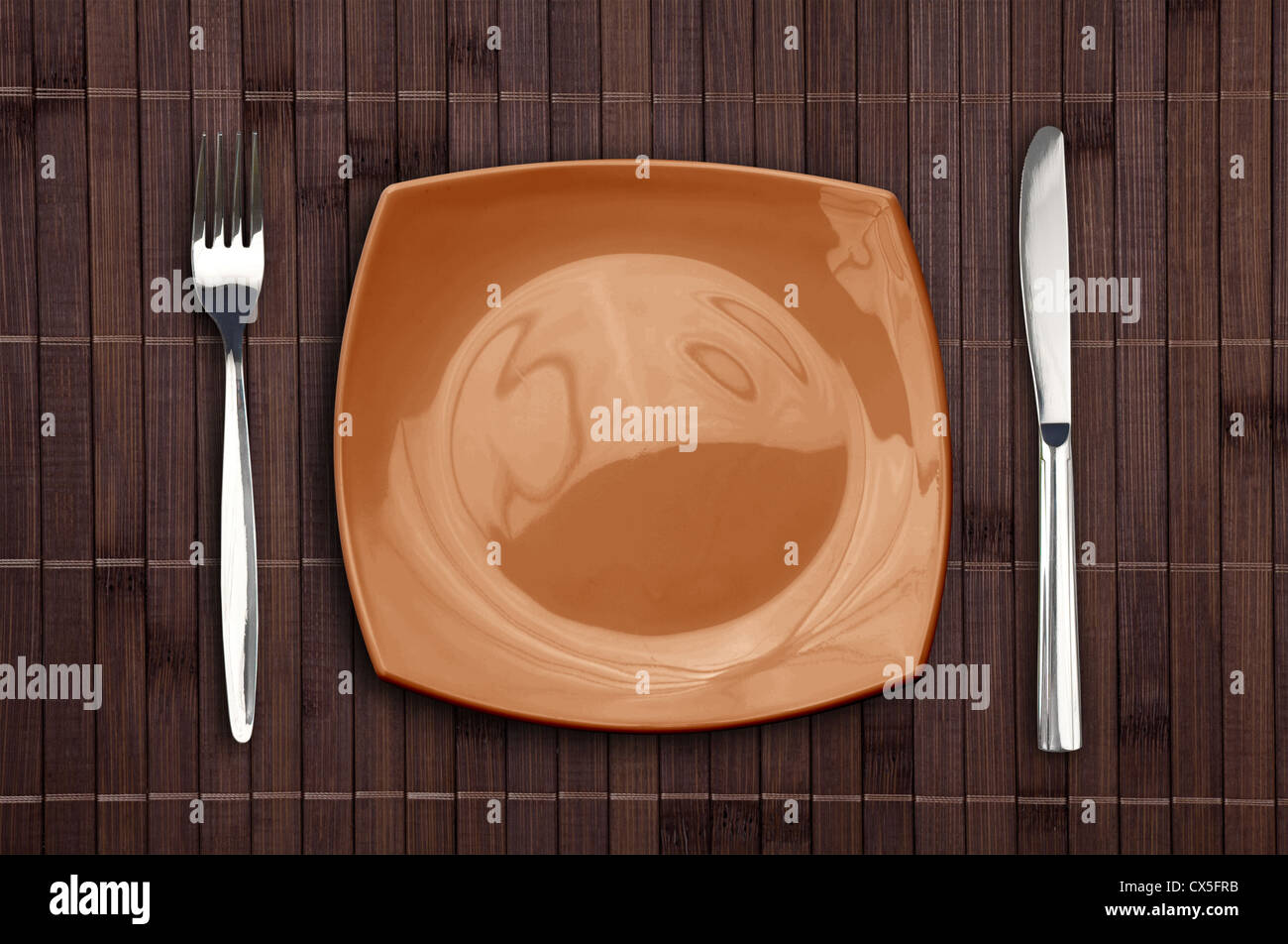 Bamboo placemat with square plate fork and knife Stock Photo