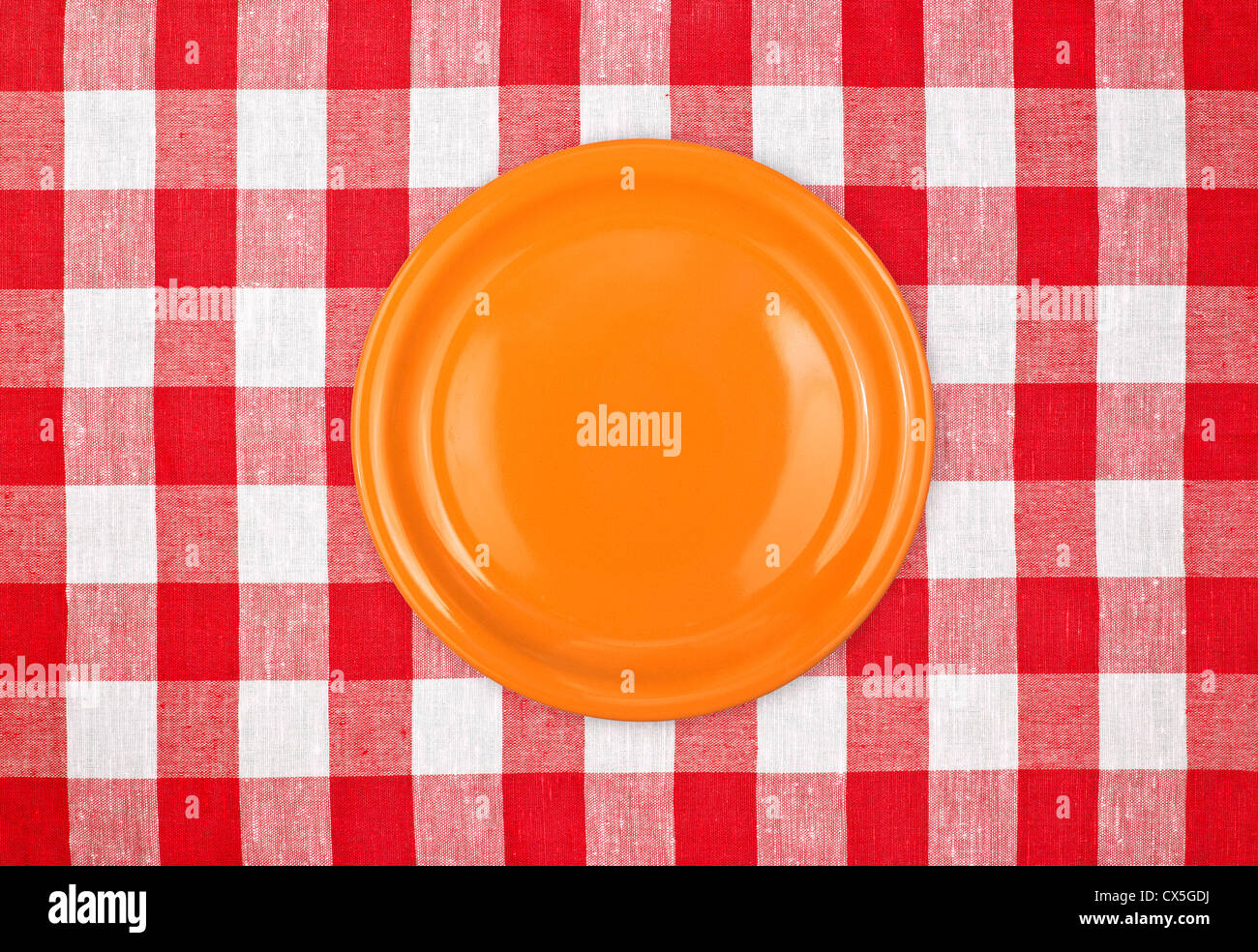 white plate on red checked tablecloth Stock Photo