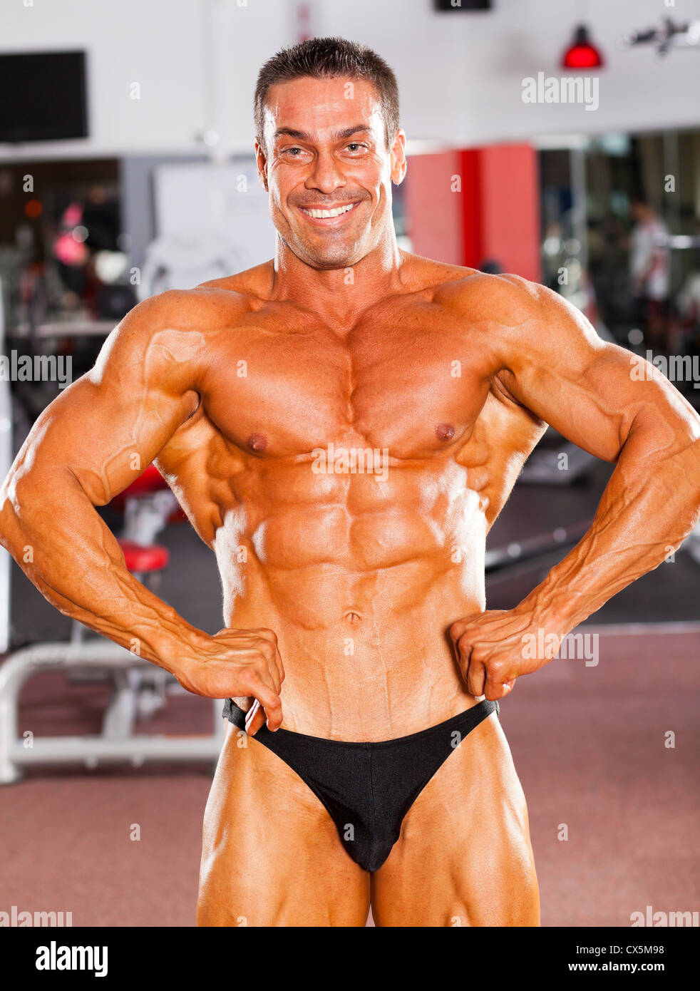 male bodybuilder flexing his muscle in gym Stock Photo