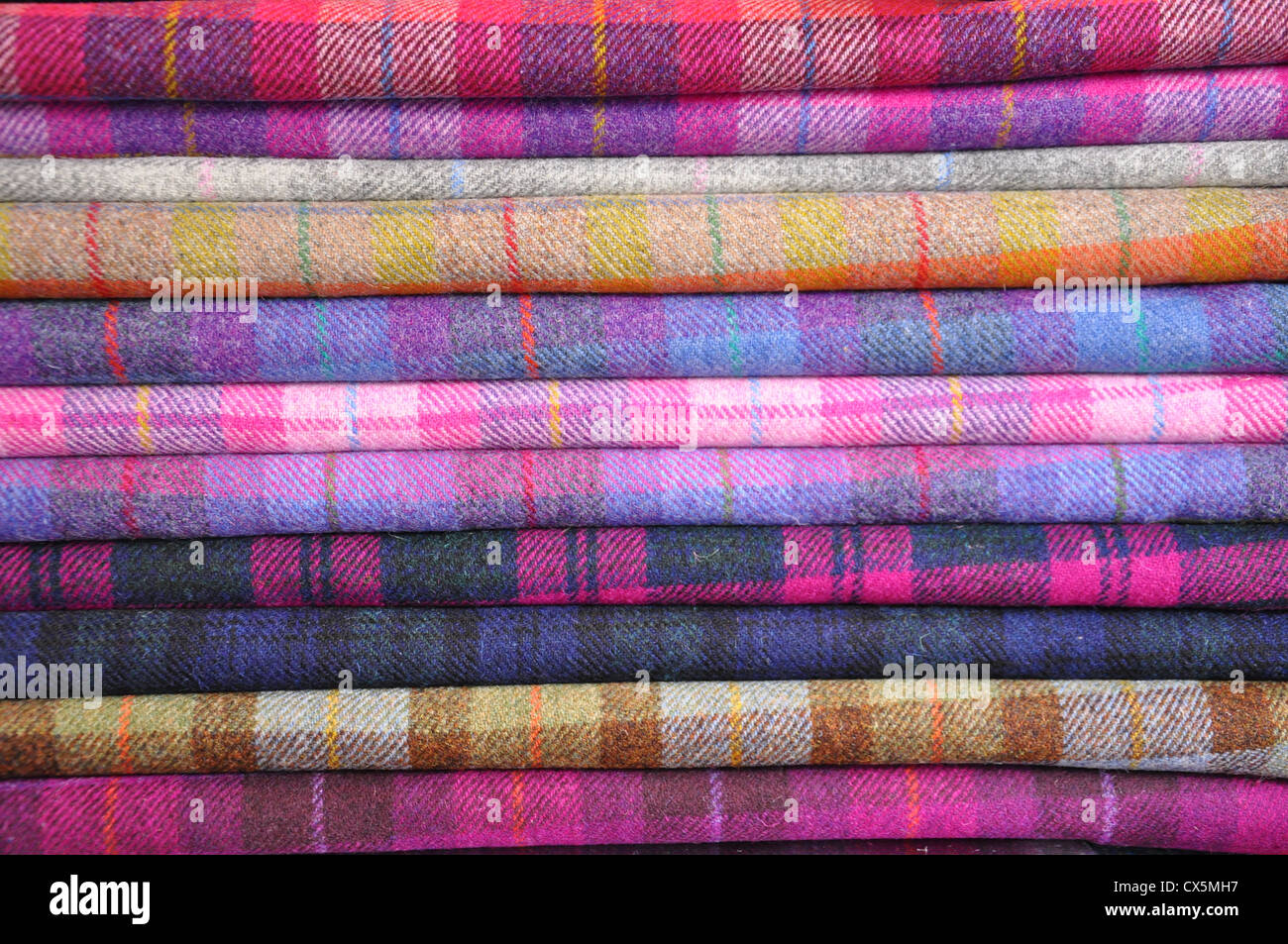 A stack of folded Harris Tweed in shades of pink and purple Stock Photo