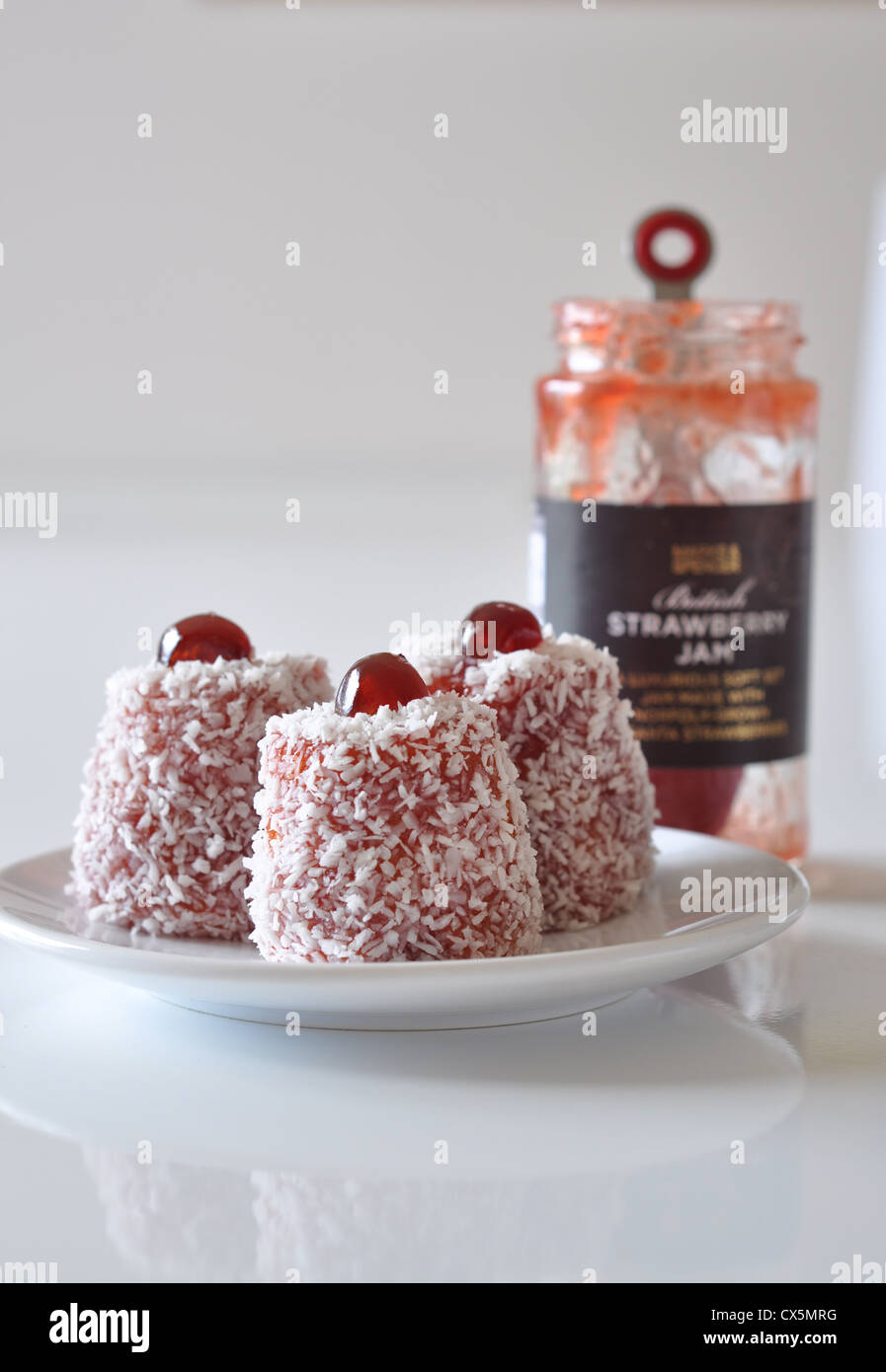 A plate of English Madeliene cakes with a jar of jam behind Stock Photo