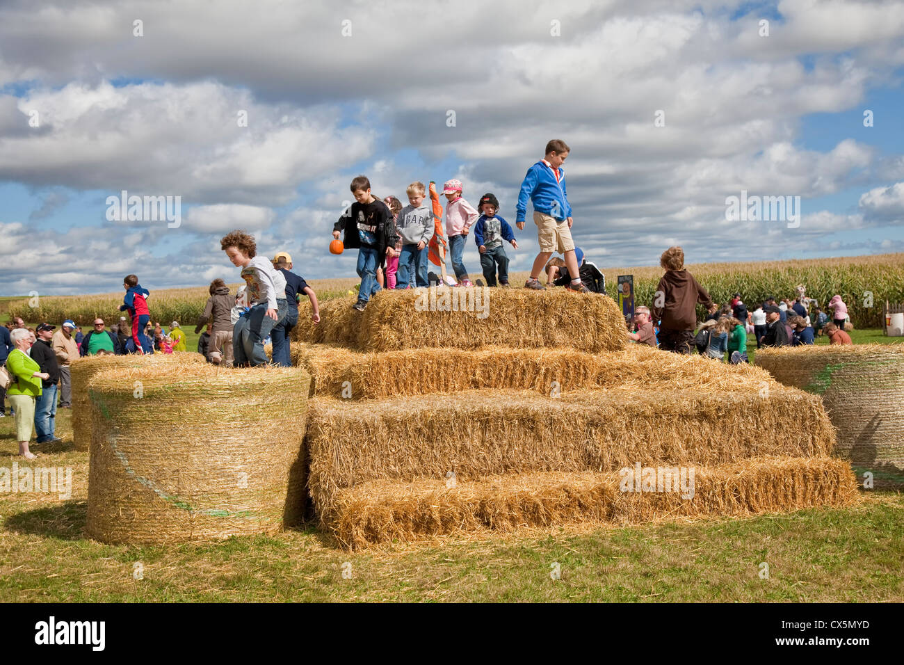 Children climbing and playing on a hay bale mountain at  the annual Scarecrow Festival held in Summerside, Prince Edward Island, Stock Photo