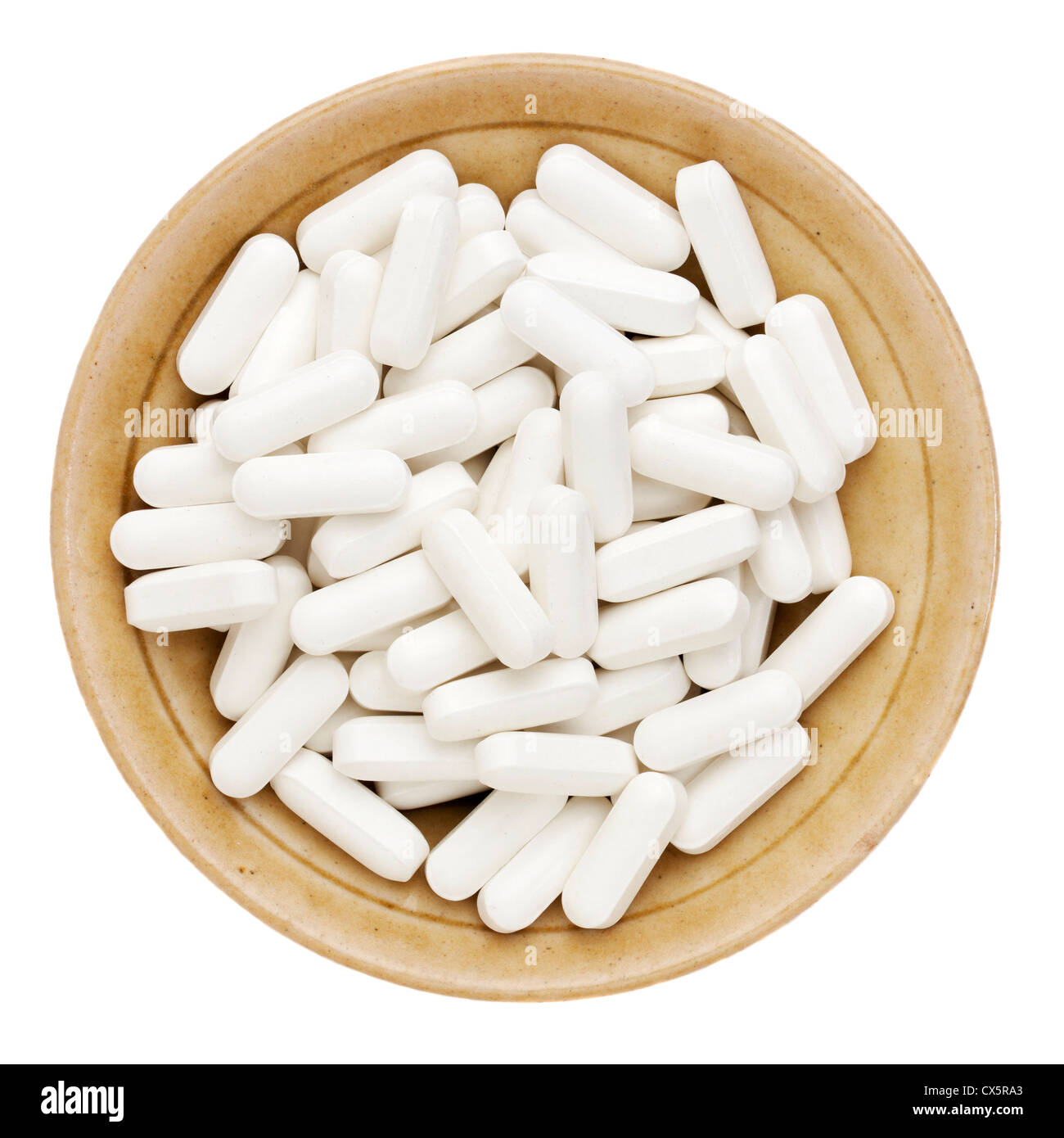 white vitamin, supplement or drug pills in a small ceramic bowl Stock Photo