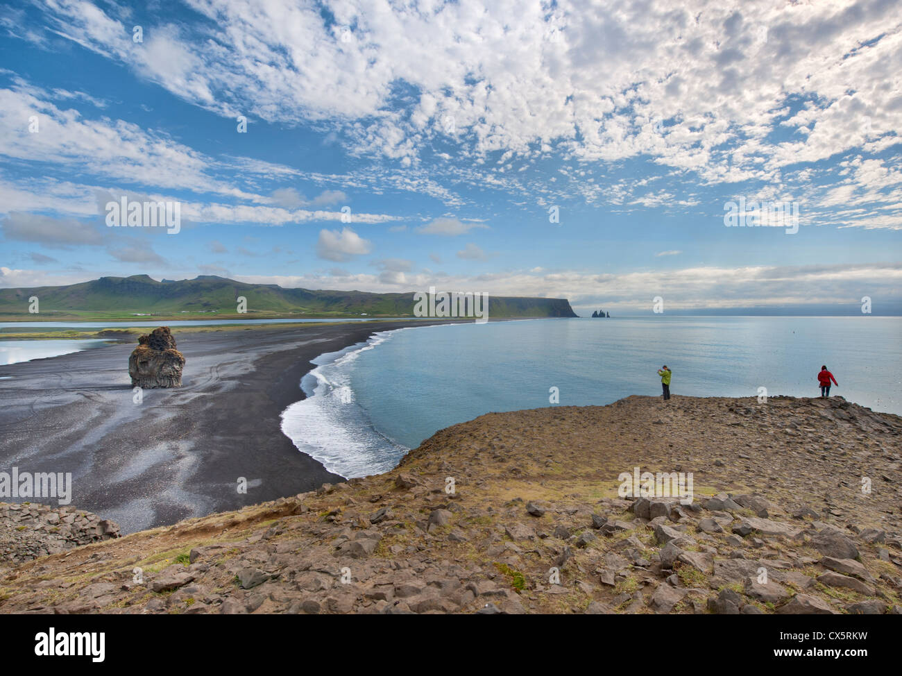 A view of a long black sand beach near Dyrhólaey in South Iceland with interesting rock formations Stock Photo