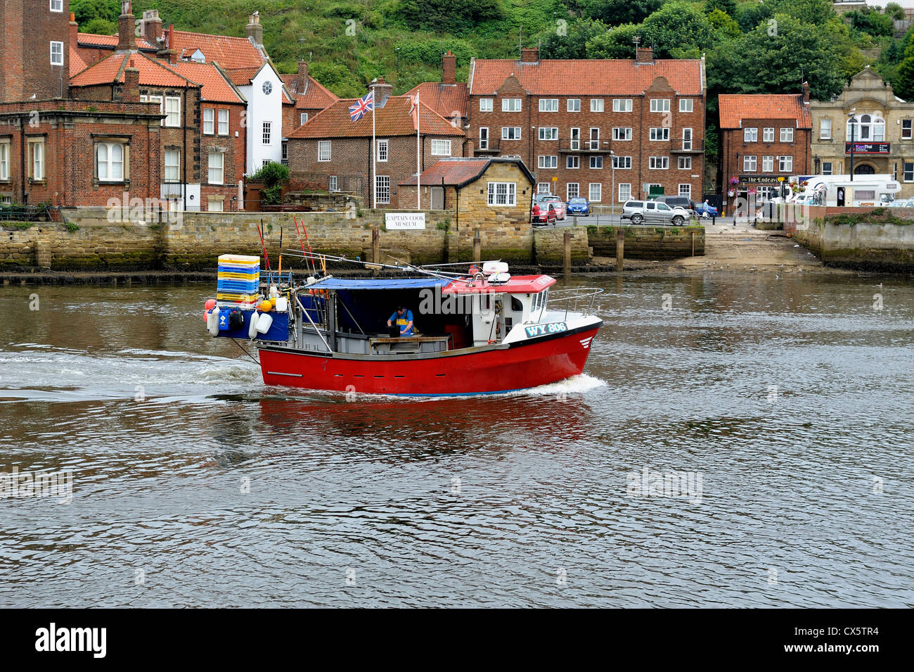 A Fishing boat returning to the harbour whitby north yorkshire england ...