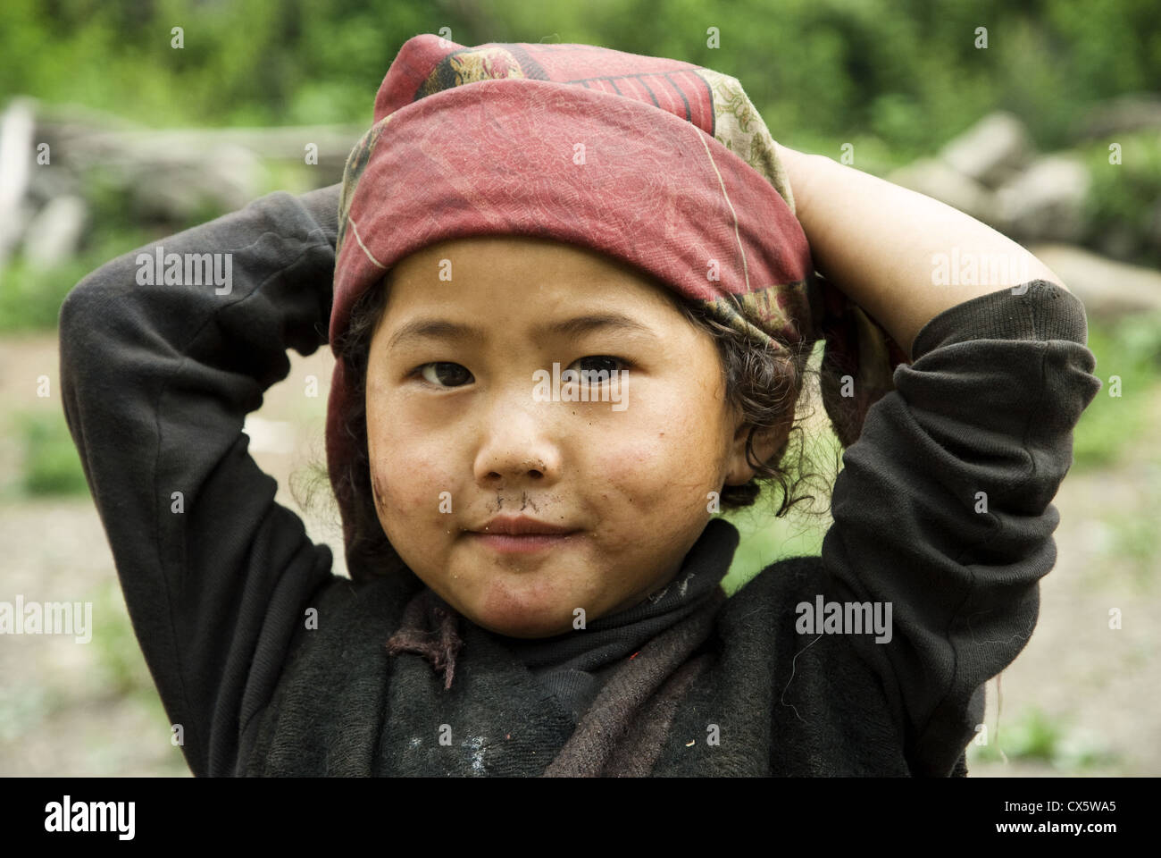 This small Gurung girl in lower Tsum Valley, Nepal, with whose family I overnighted, is totally unafraid of a strange foreigner Stock Photo