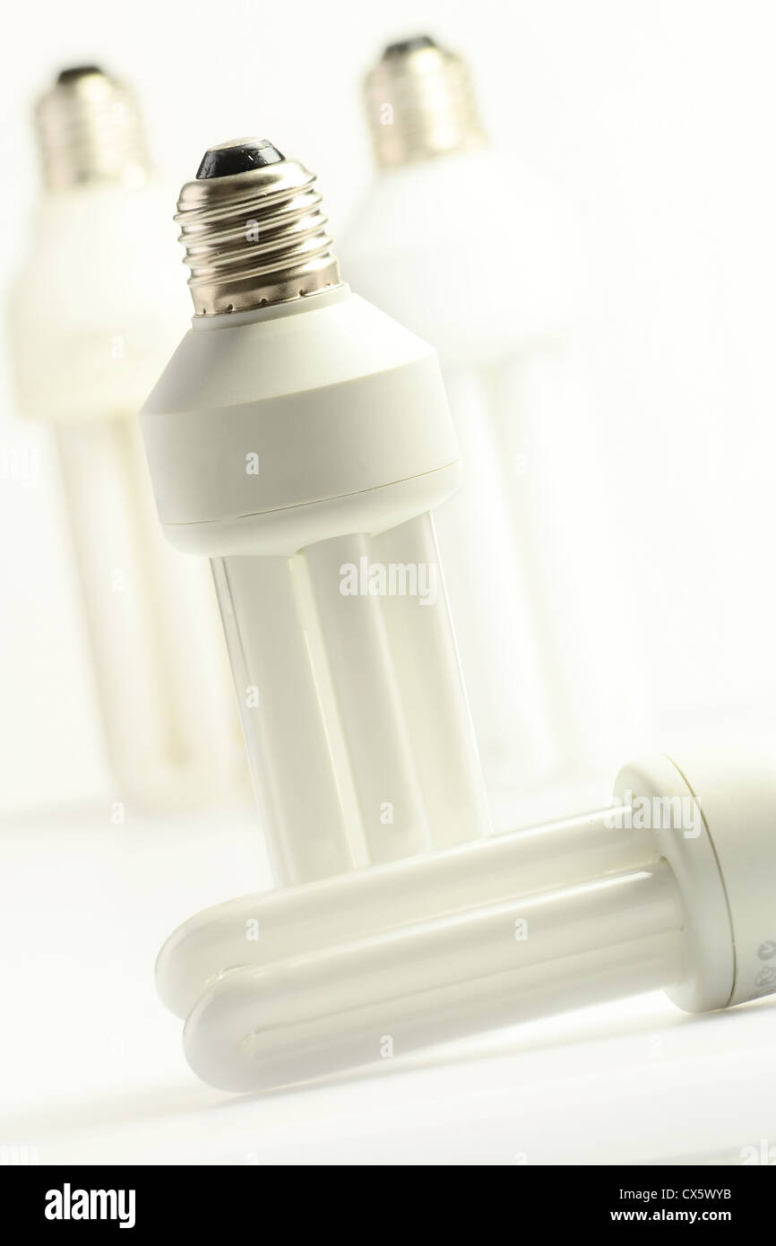 Compact fluorescent lamp on green background. Energy saving light bulb ...