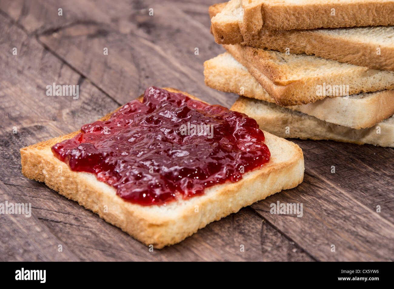 Jam on toast on wooden background Stock Photo Alamy