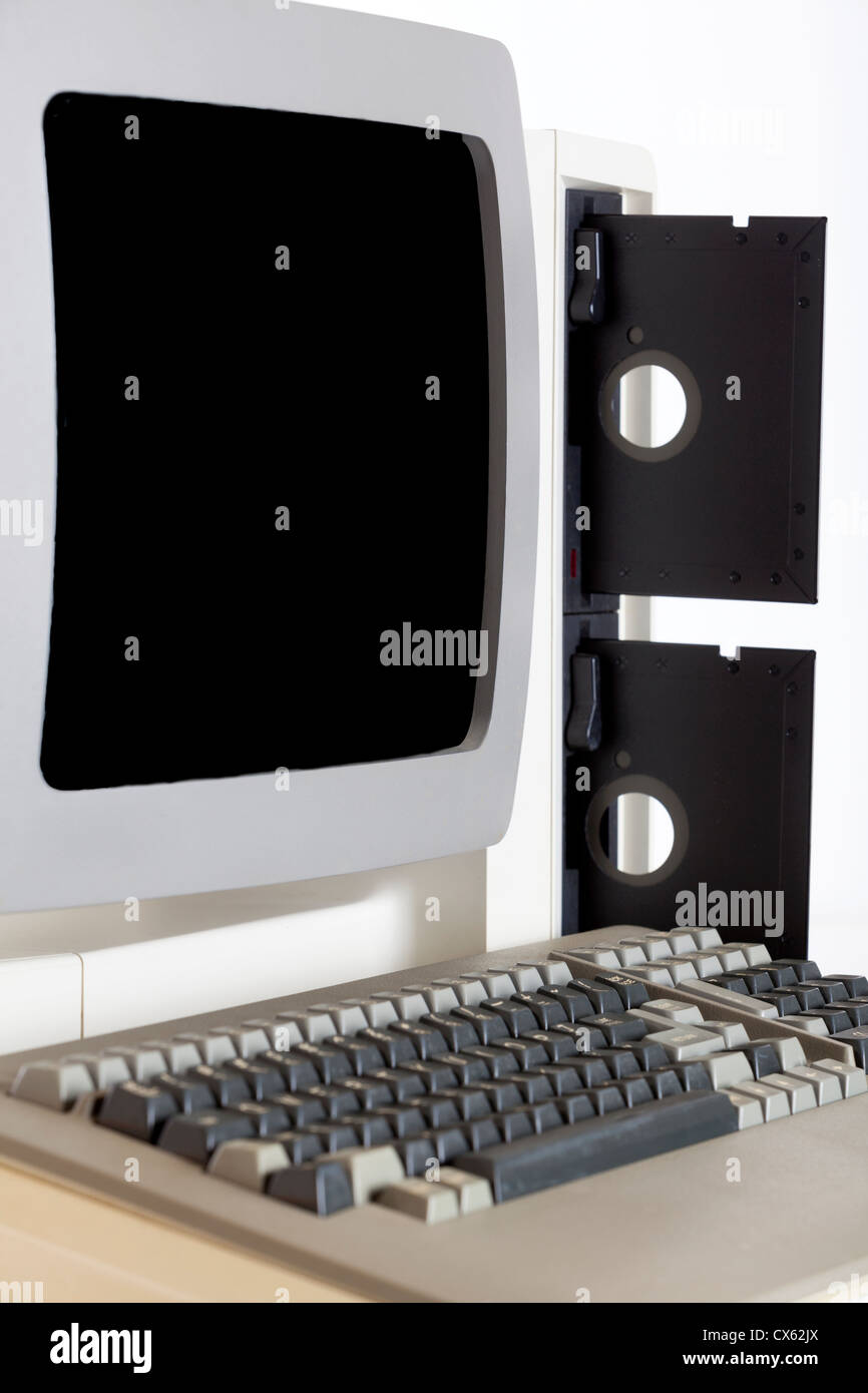 1980's PC desktop computer and monitor with 5 1/4 floppy disc drives and floppy discs. Stock Photo