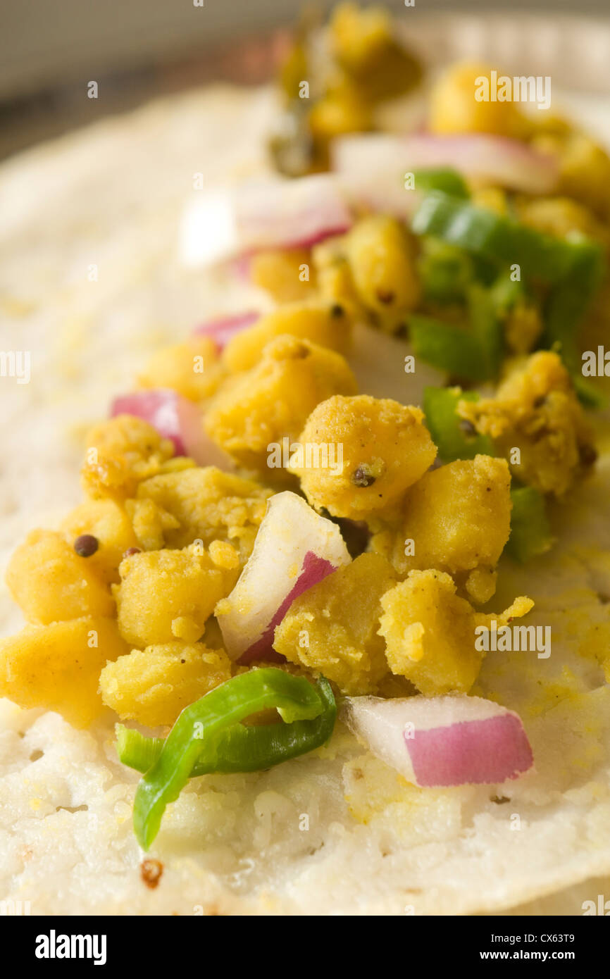 The inside of a home made masala dosa showing the spicy potato filling
