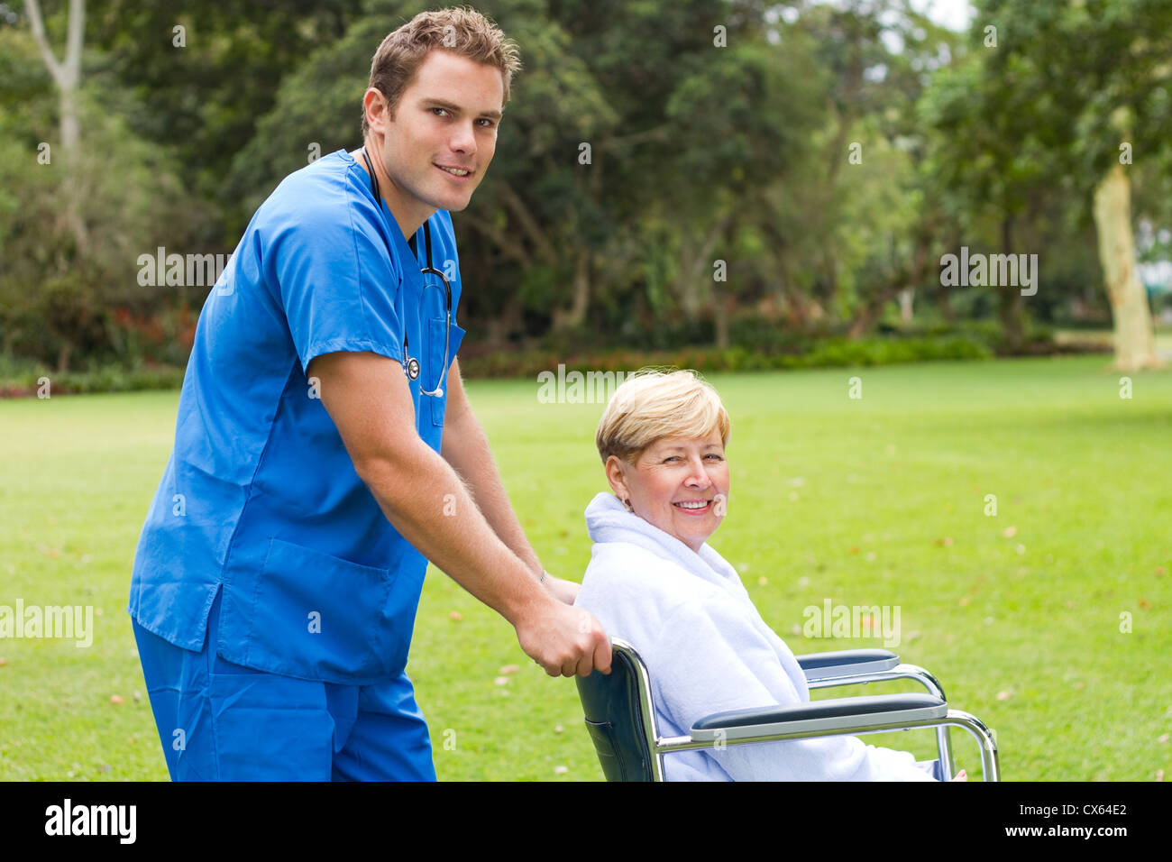 male nurse pushing a senior patient on wheelchair outdoors Stock Photo ...