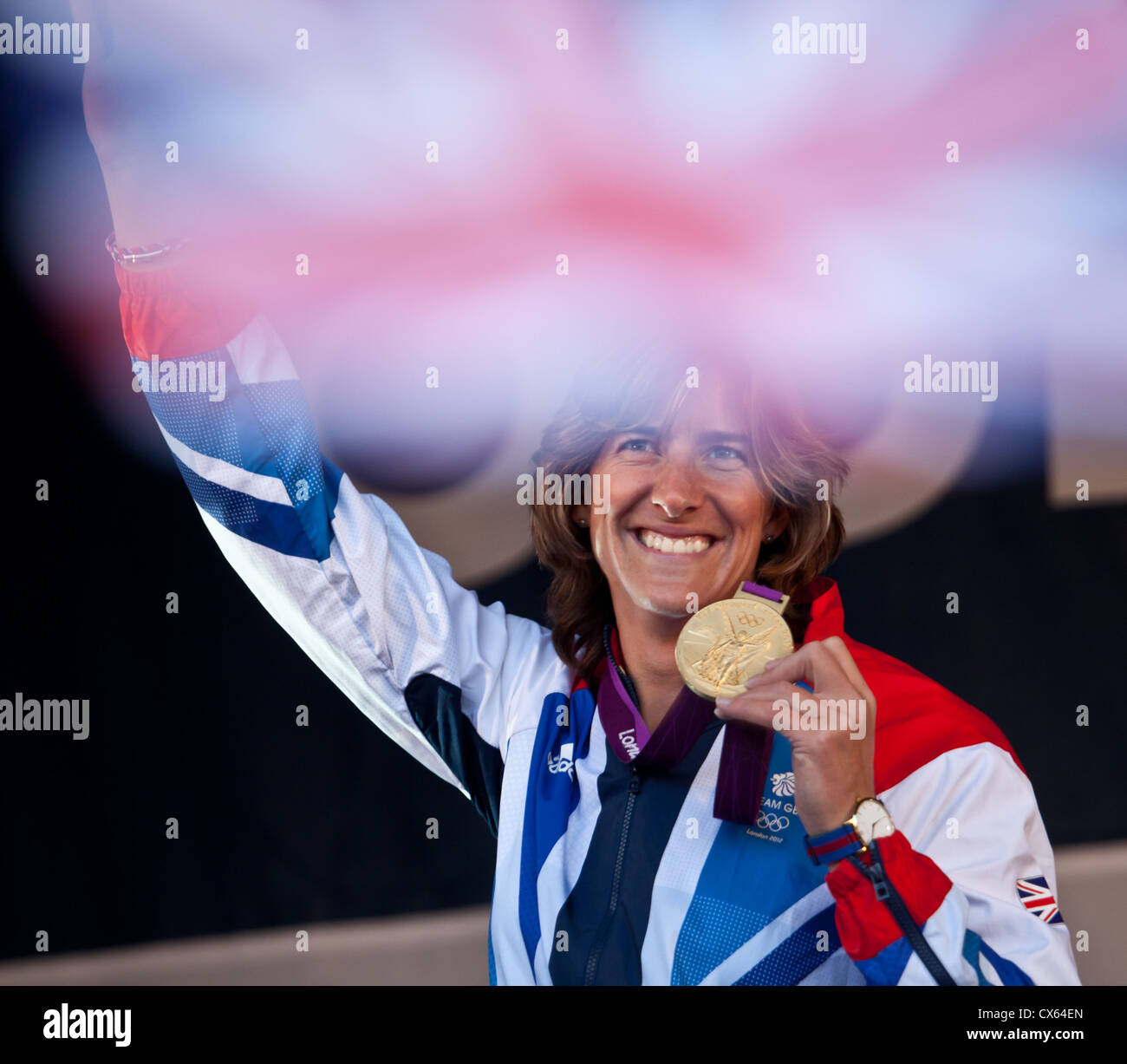 Katherine Grainger, Olympic rowing Gold Medallist, holds her medal. Union flag out of focus at top. George Square, Glasgow Stock Photo