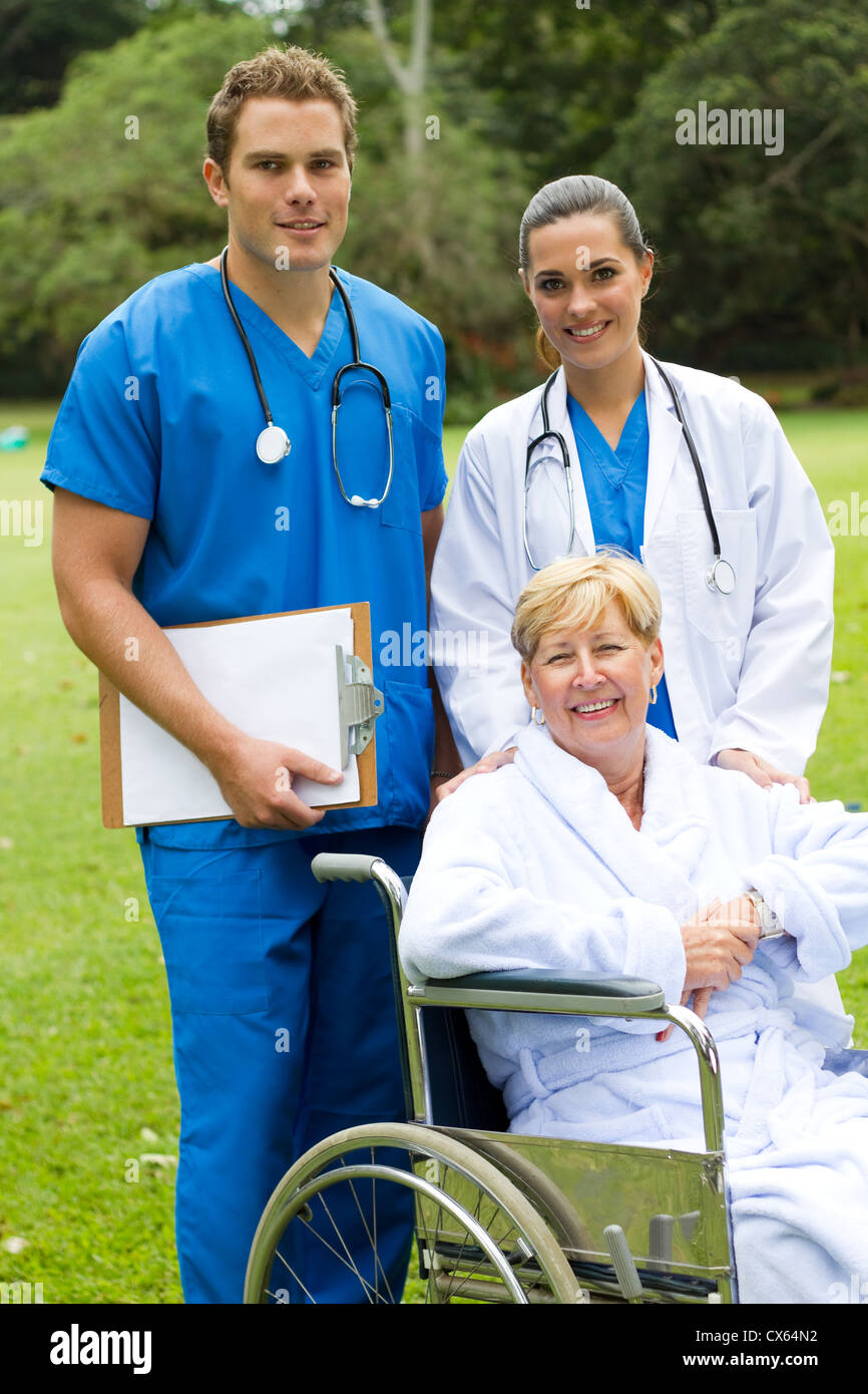 group portrait of doctor, nurse and senior patient in hospital garden Stock Photo