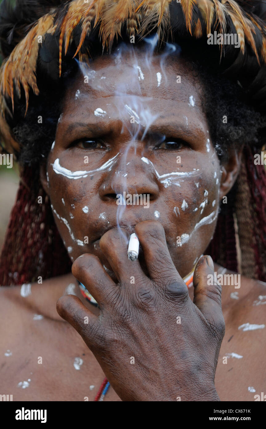 A tribal woman with severed fingers in the Baliem Valley, West Papua, Indonesia. Fingers are amputated to mourn relatives. Stock Photo