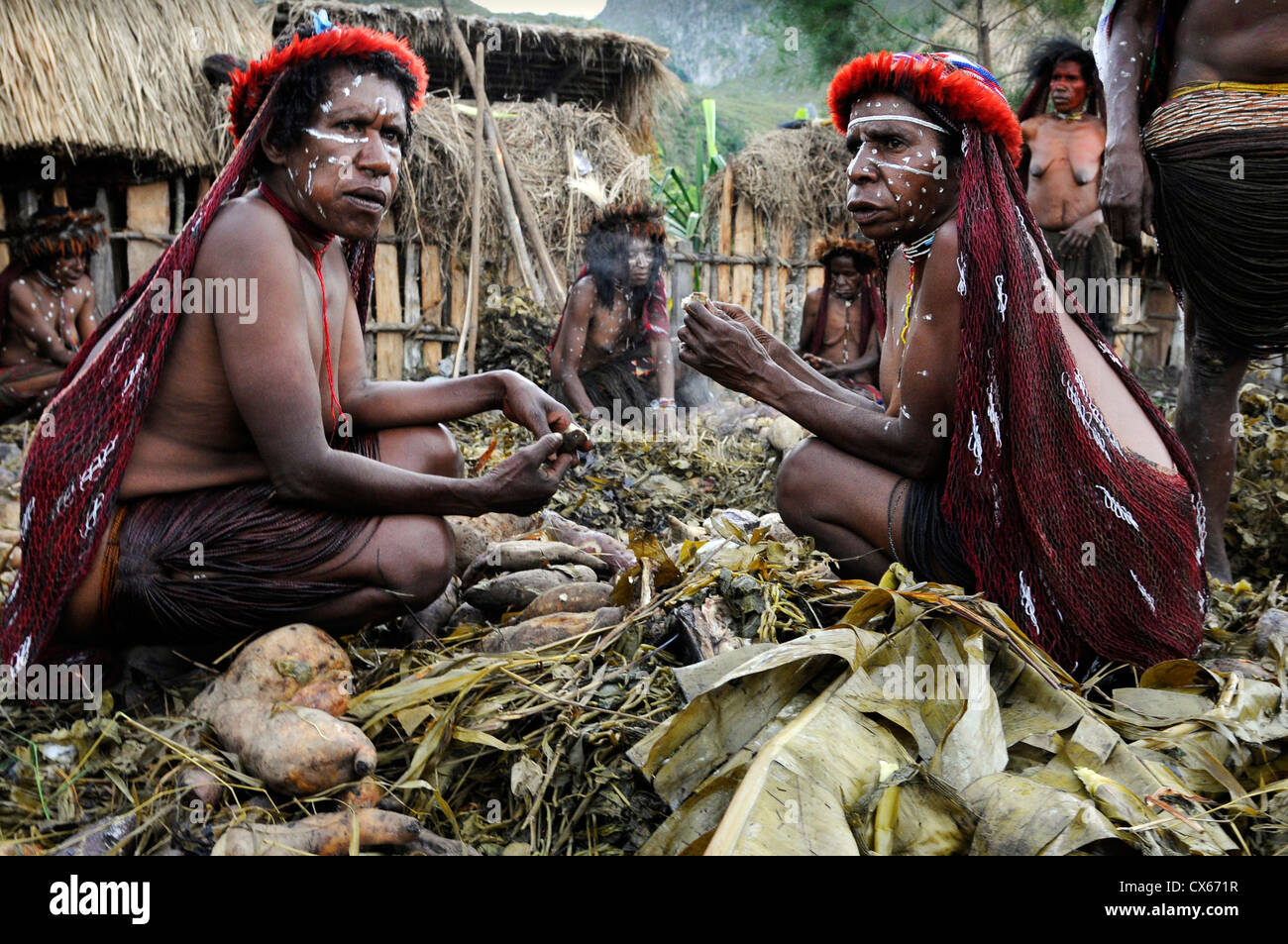 Communal cooking and eating in a ground oven in the Baliem Valley, West Papua, Indonesia. Stock Photo