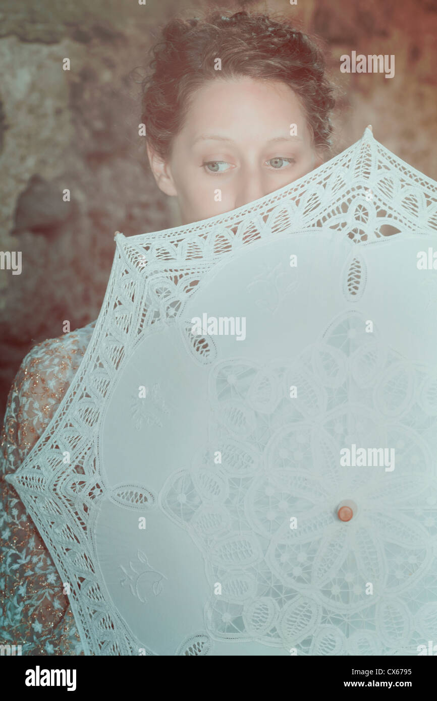a woman is hiding herself behind a parasol Stock Photo