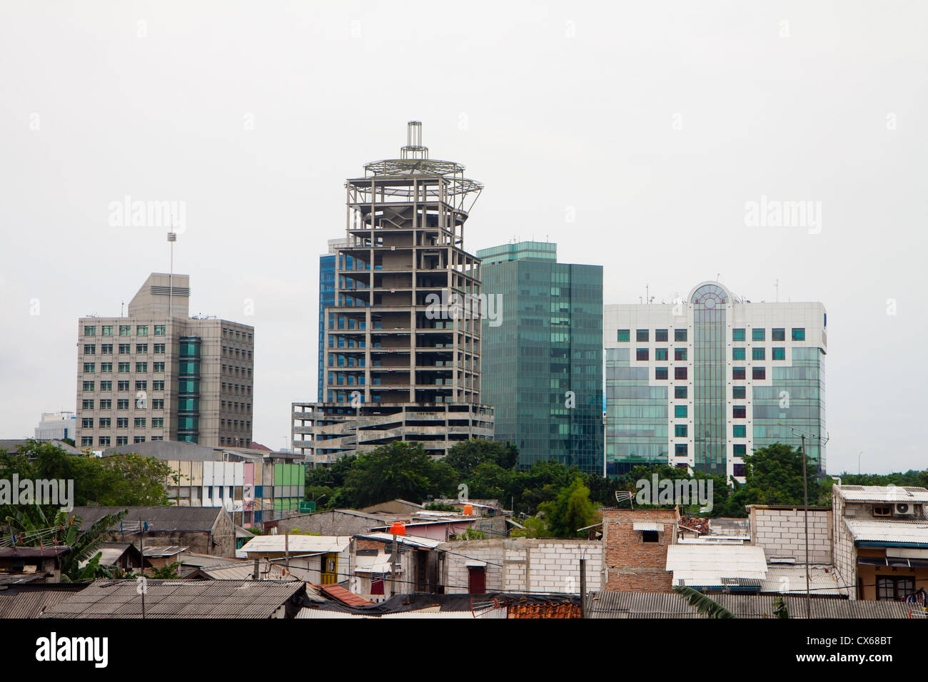 Office building construction foregrounded by neighboring slums in a city of the third world country. Stock Photo