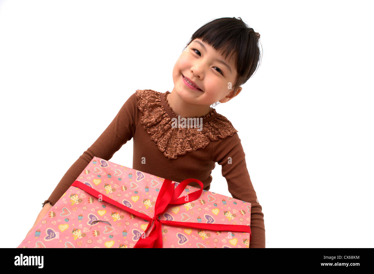 A cute young girl holding a Christmas gift Stock Photo - Alamy