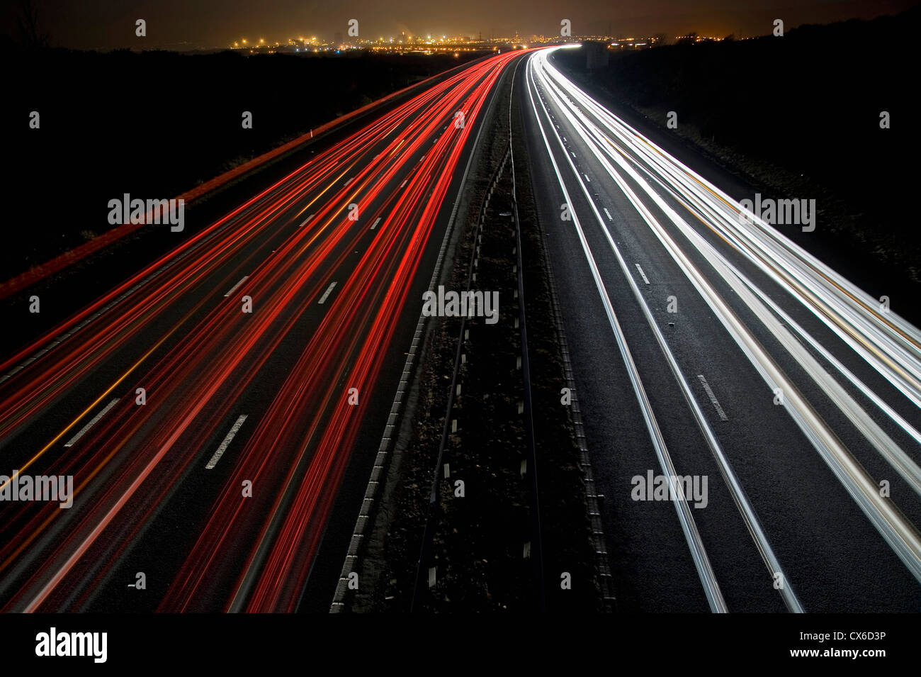 Light Trails on the M4 Motorway neat Port Talbot in South Wales with Port Talbot Steel Works lighting up the distance. Stock Photo
