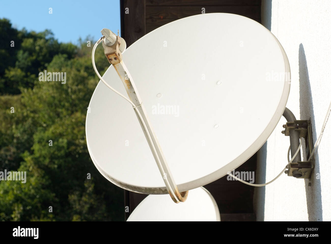 Satellite television dish on the house wall Stock Photo