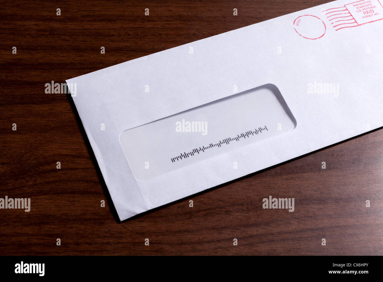A window envelope with no address, but a barcode and red ink postage