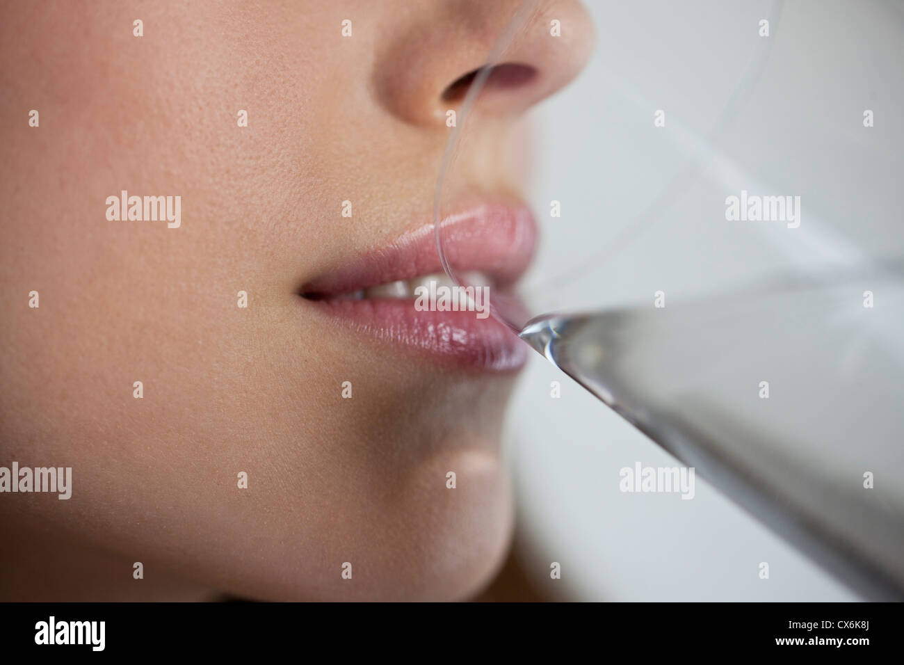 A young woman drinking a glass of water, close up of mouth Stock Photo -  Alamy