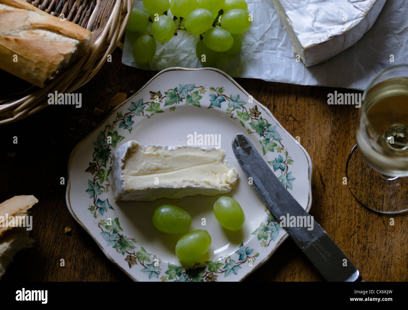 Plate of ripe Brie with grapes, bread and wine to the side Stock Photo