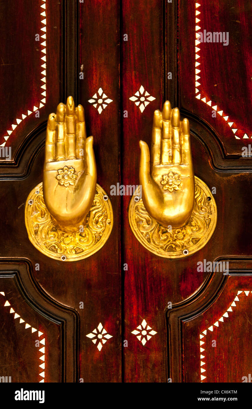 USA, Wooden carved door with golden brass hands-handles in the door way, Riviera Maya, Mexico Stock Photo
