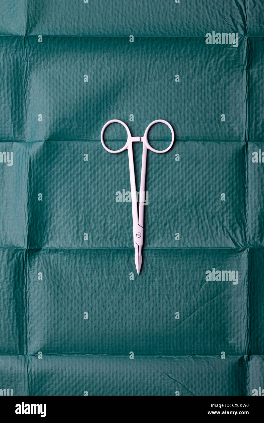 A pair of surgical scissors on a surgical drape Stock Photo
