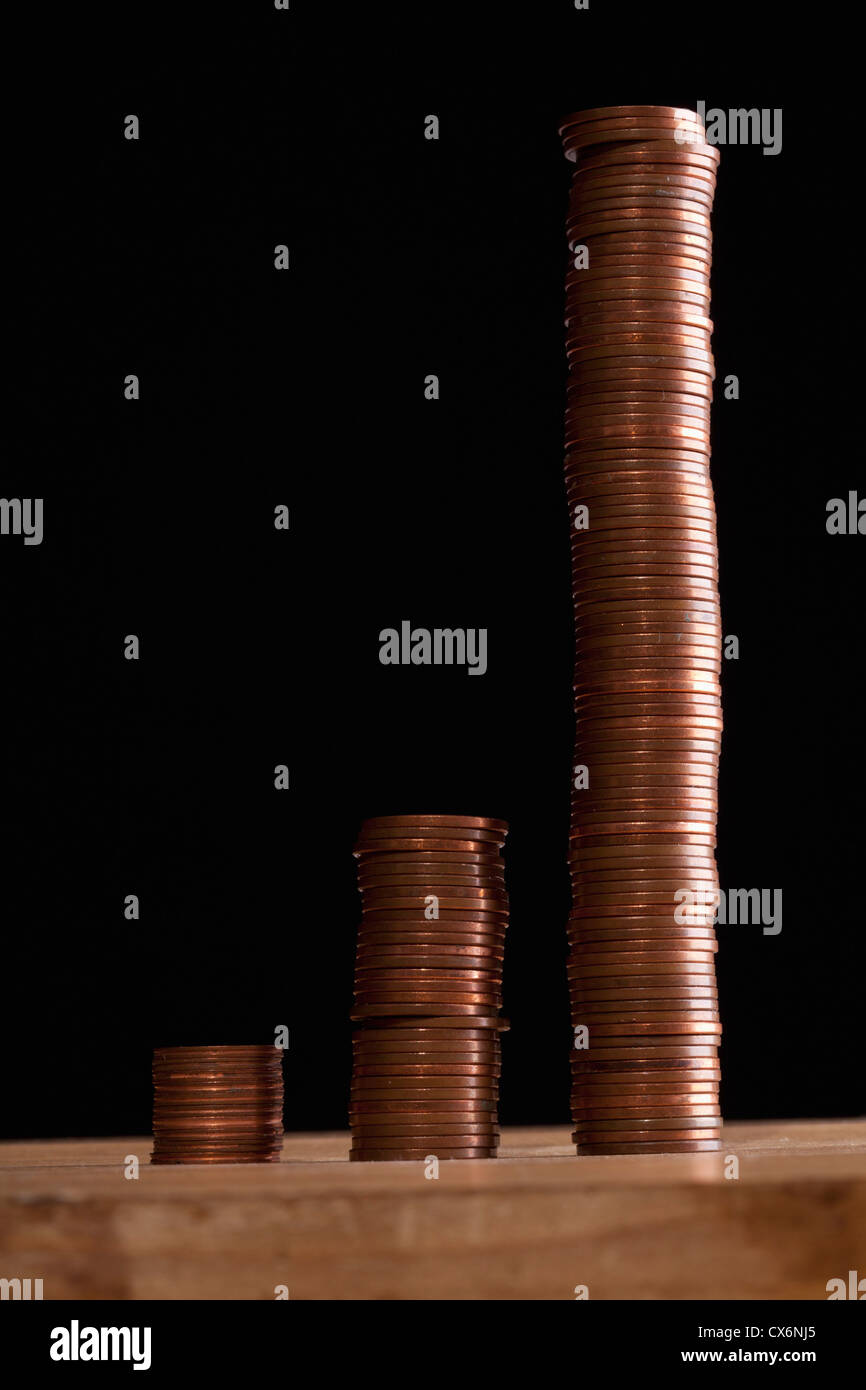 Three rows of stacks of copper coins increasing in size Stock Photo