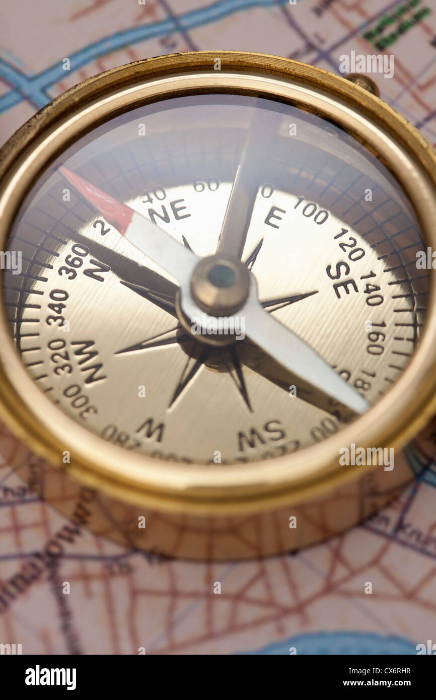 A compass on top of a road map, focus on compass Stock Photo