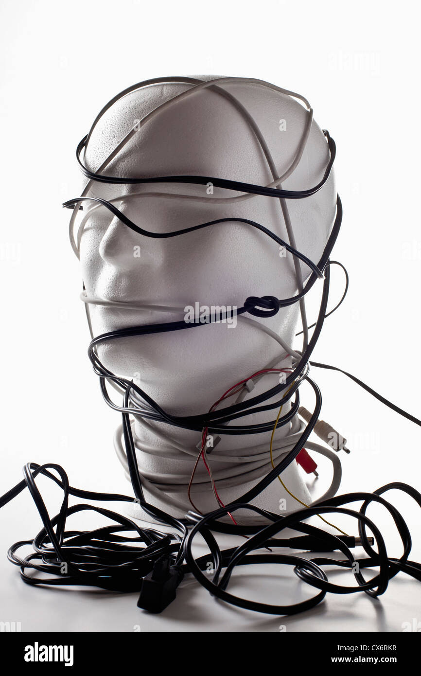 A white mannequin bust entangled in various cords and cables Stock Photo