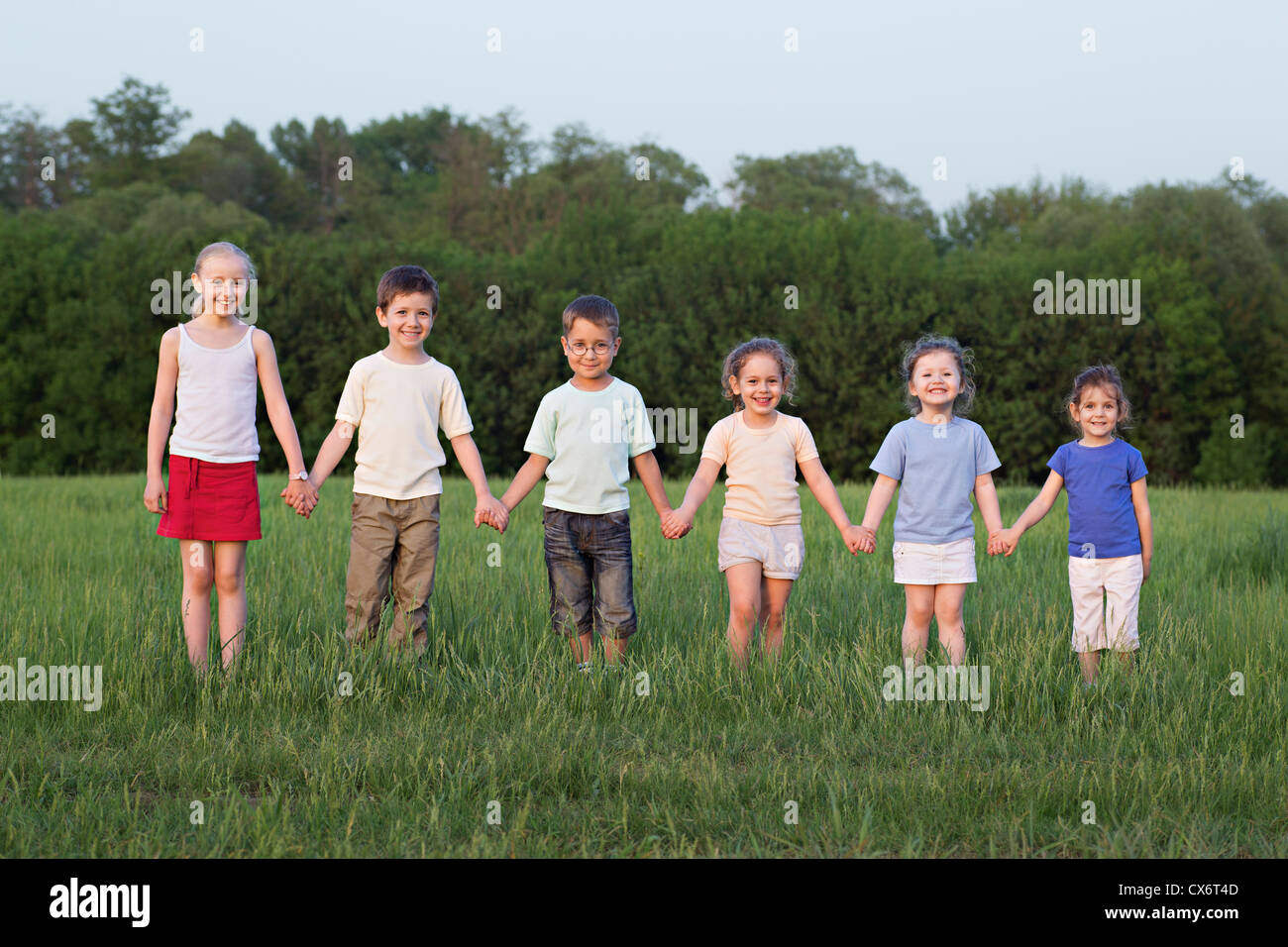 Portrait of children holding hands in a field Stock Photo - Alamy