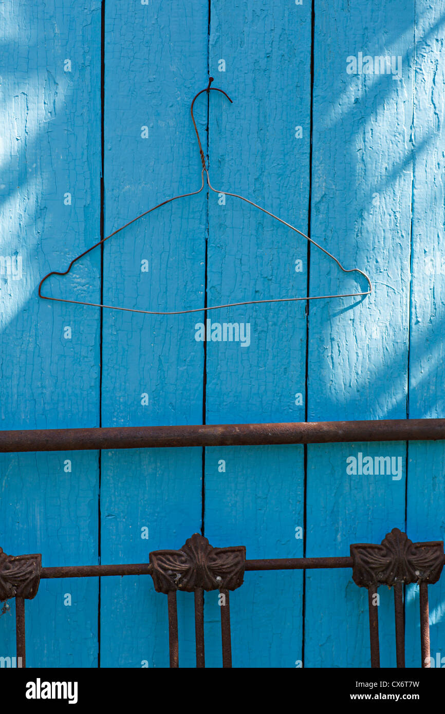 A wire coat hanger on a blue wall Stock Photo