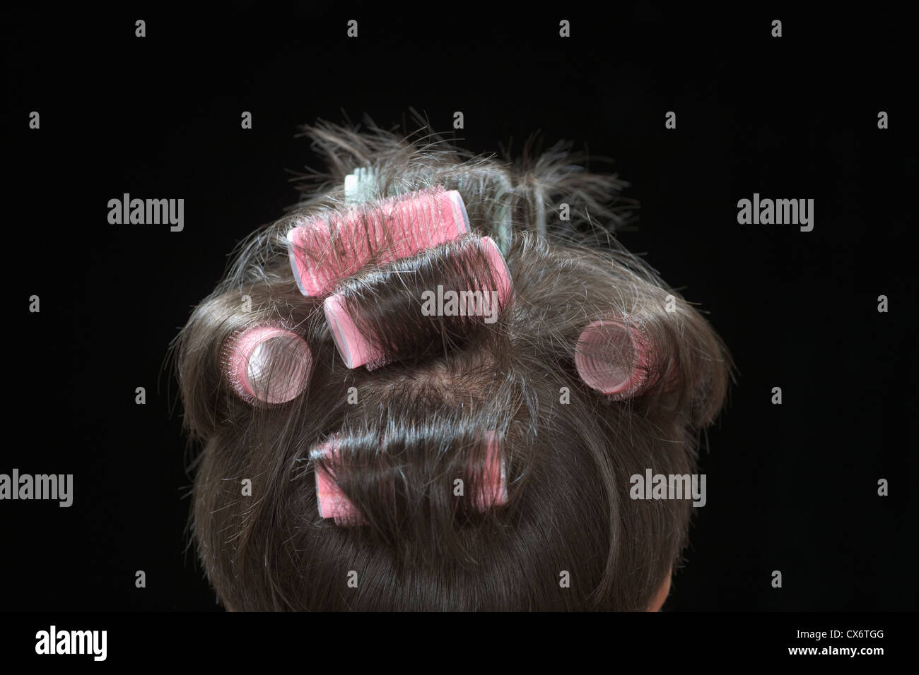 Rear view of a woman with curlers in her hair Stock Photo