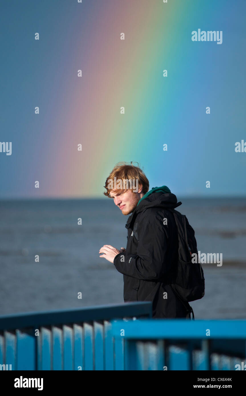 Ginger haired boy looking at rainbow over Belfast Lough Stock Photo