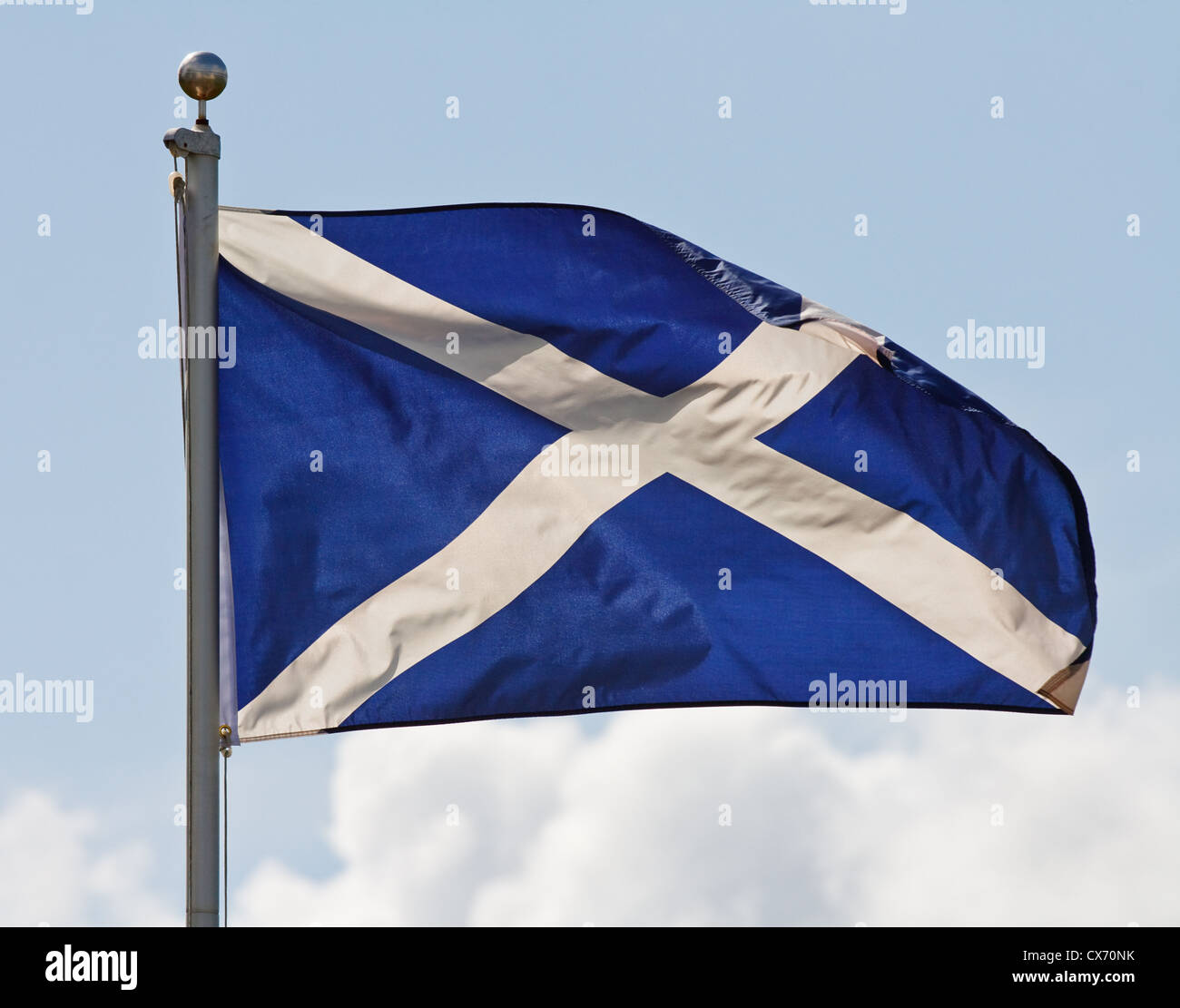 the blue and white cross of st andrew the national flag of scotland ripples in the wind on flagpole Stock Photo