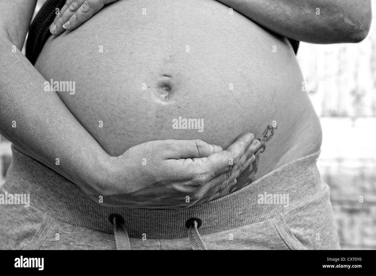 Female Holding Her Belly 25 Weeks Into Pregnancy England Uk Stock Photo Alamy