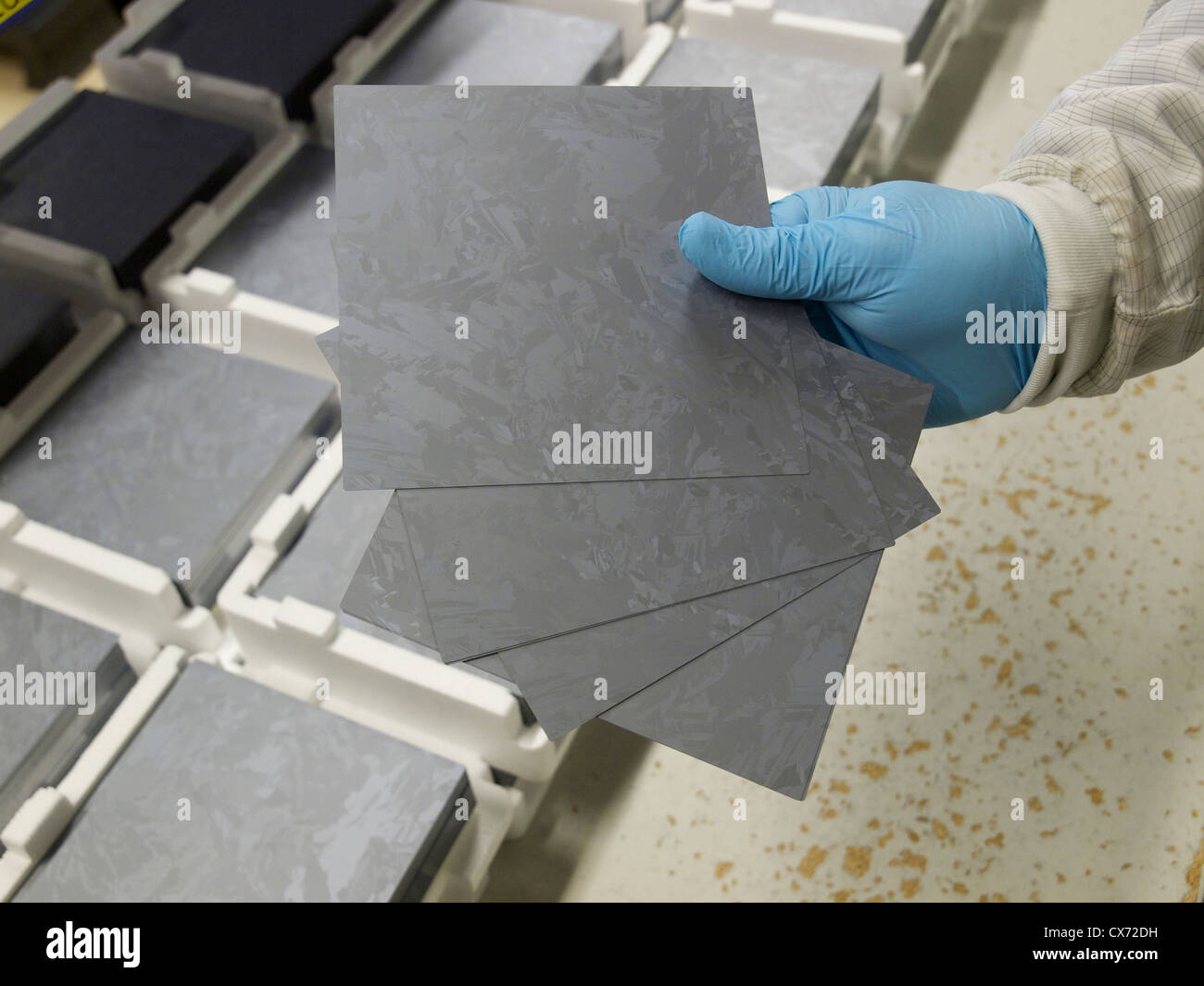 Hand holding 200 micron thick polycrystalline silicon wafers that will be used for solar cell production. Stock Photo