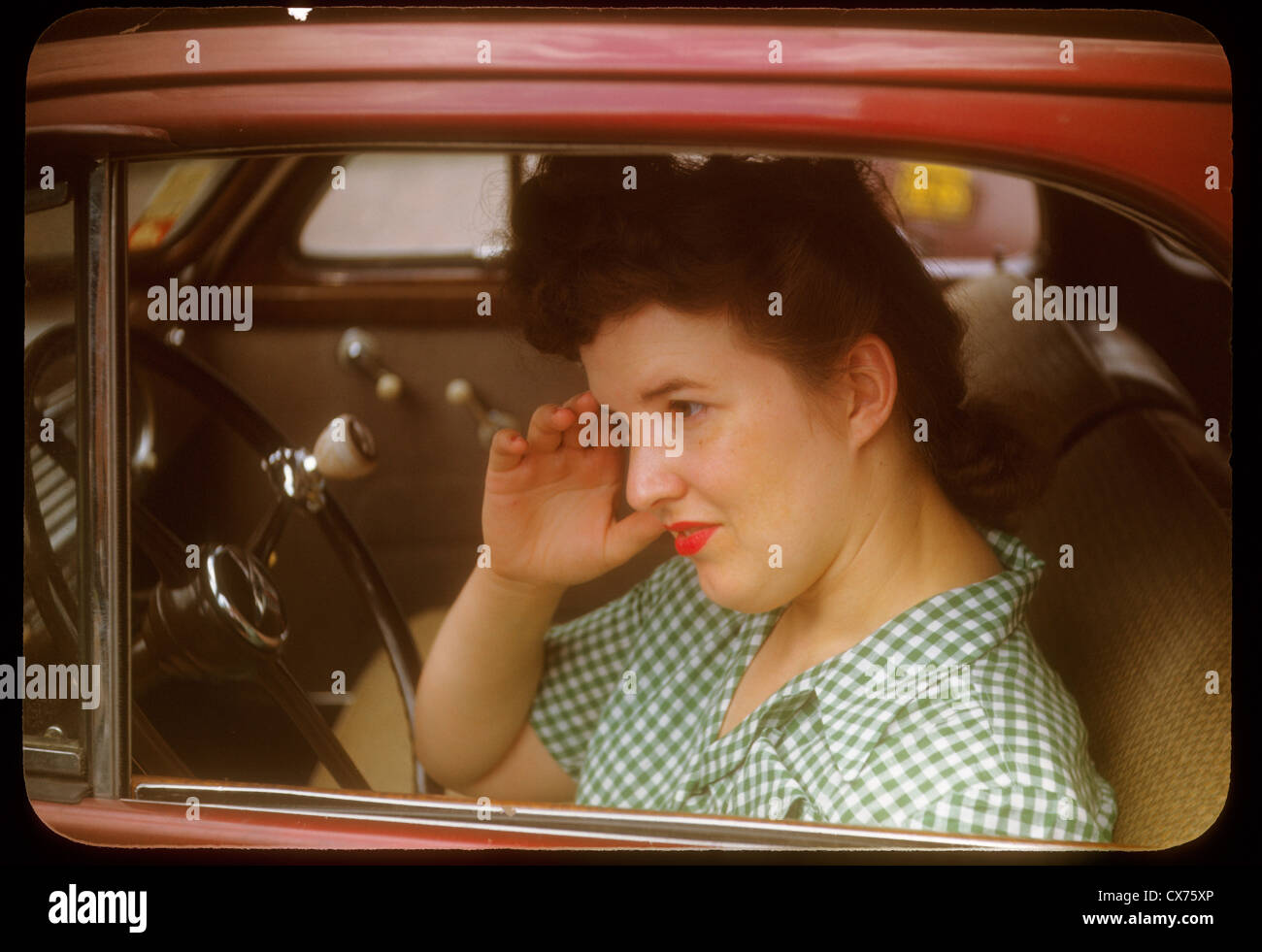 woman in 1940s car portrait kodachrome fashion Indiana midwest steering wheel drivers seat driver 1950s red lipstick makeup Stock Photo